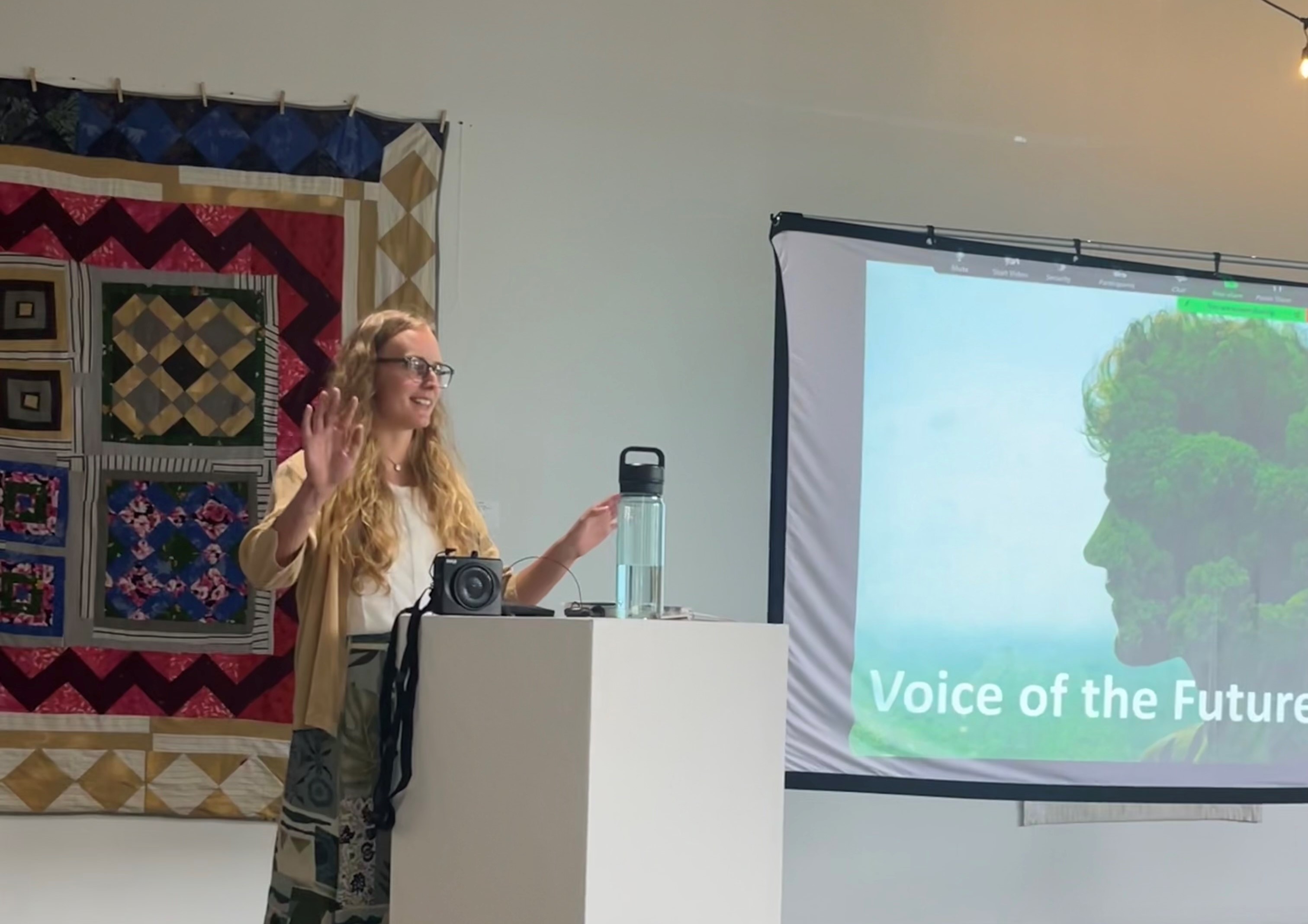 A young woman stands at a podium giving a speach.